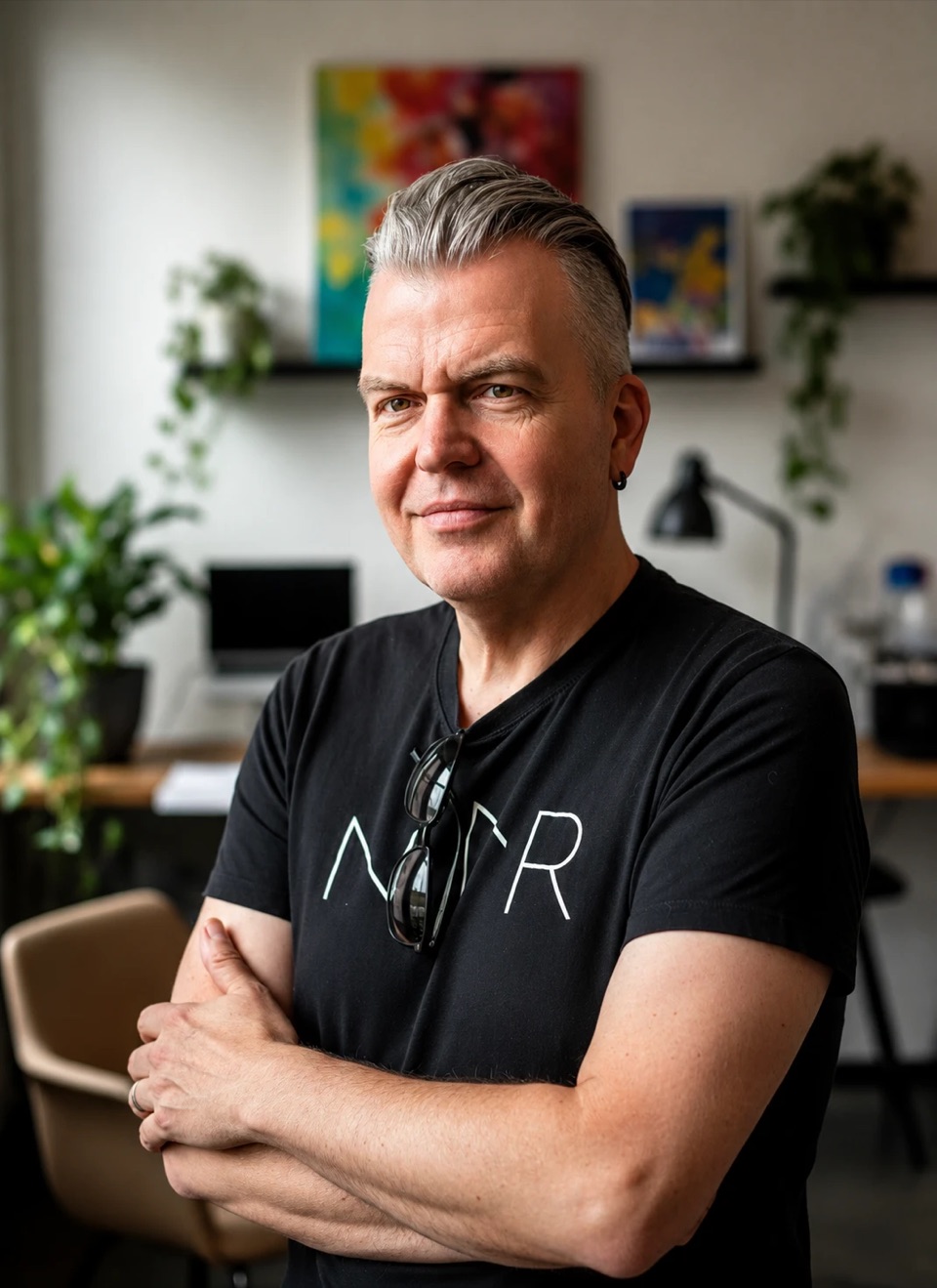 Michael Budde im Büro, die Arme verschränkt, im Hintergrund Schreibtisch und Pflanzen